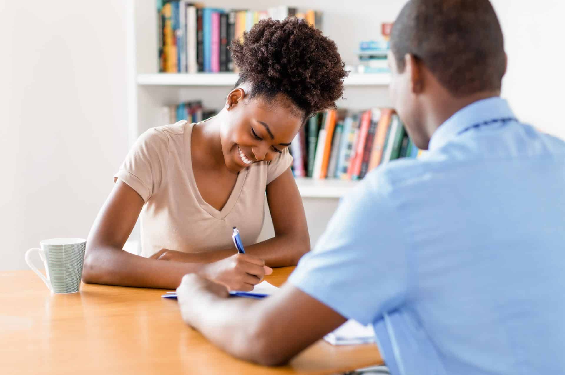 African american young adult signing contract after job interview at office of company