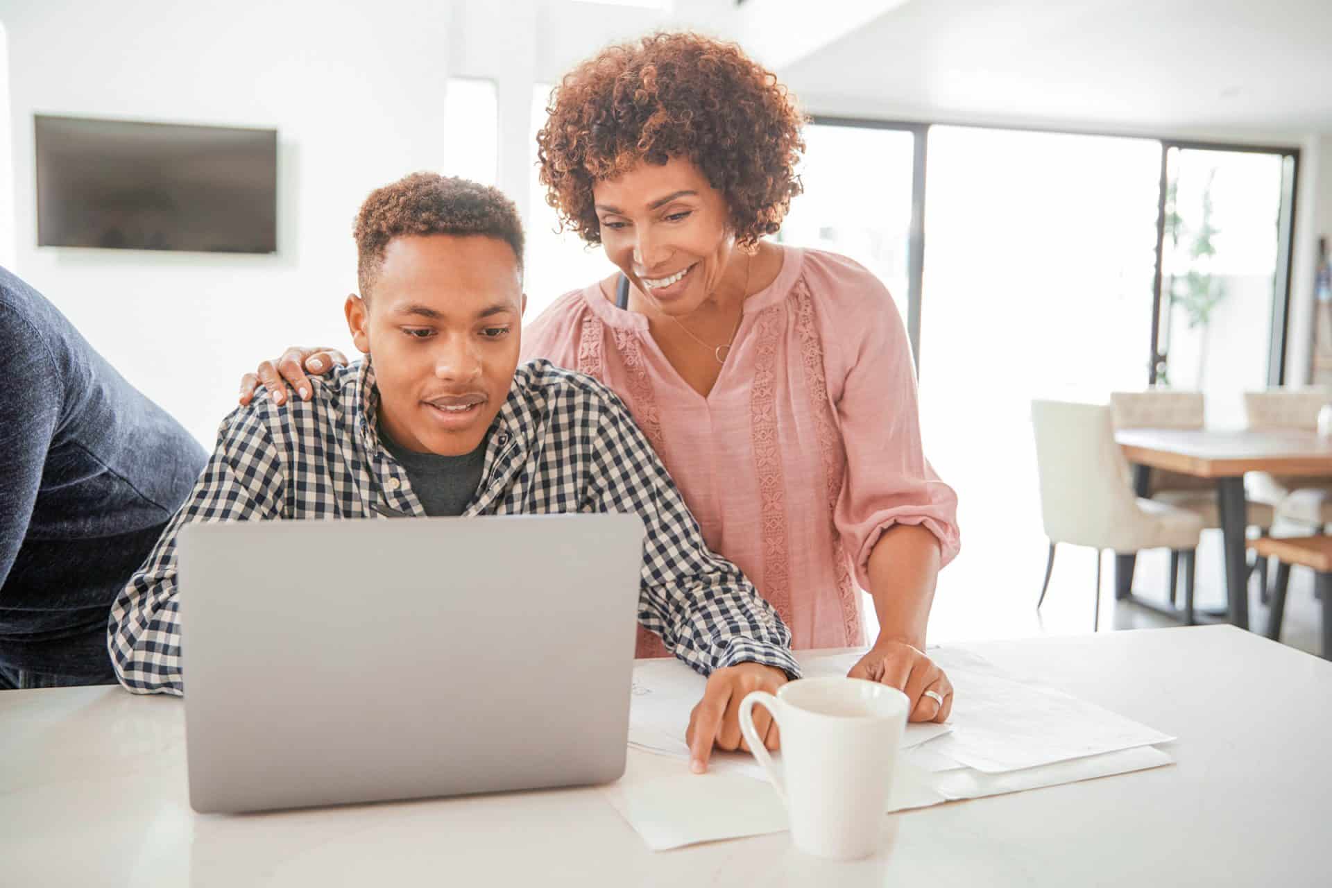 Student works on their resume with the help of a parent.