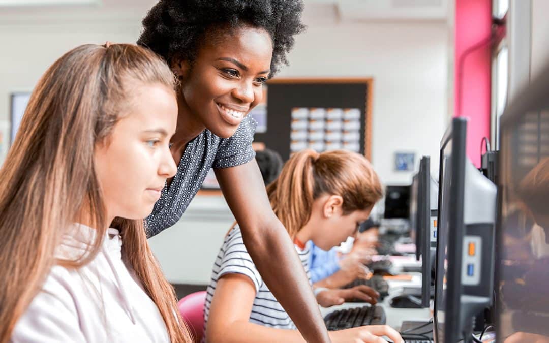 teacher helping student on computer