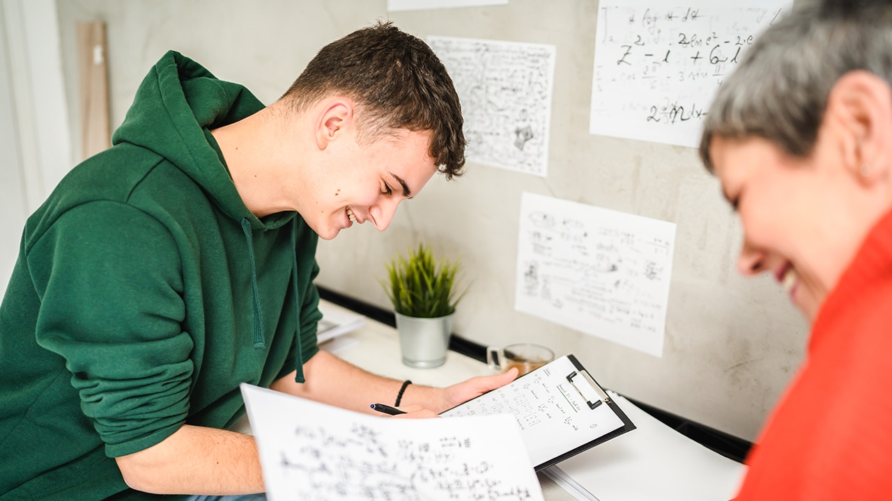 student writing on clipboard