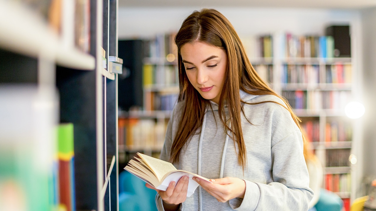 student reading book in library