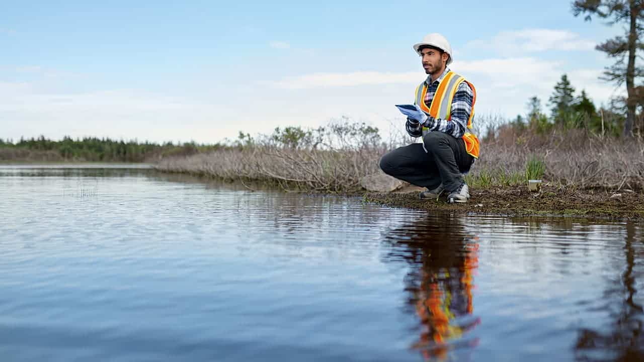 analyzing-water-test-results-on-a-tablet Man and women in field with laptop